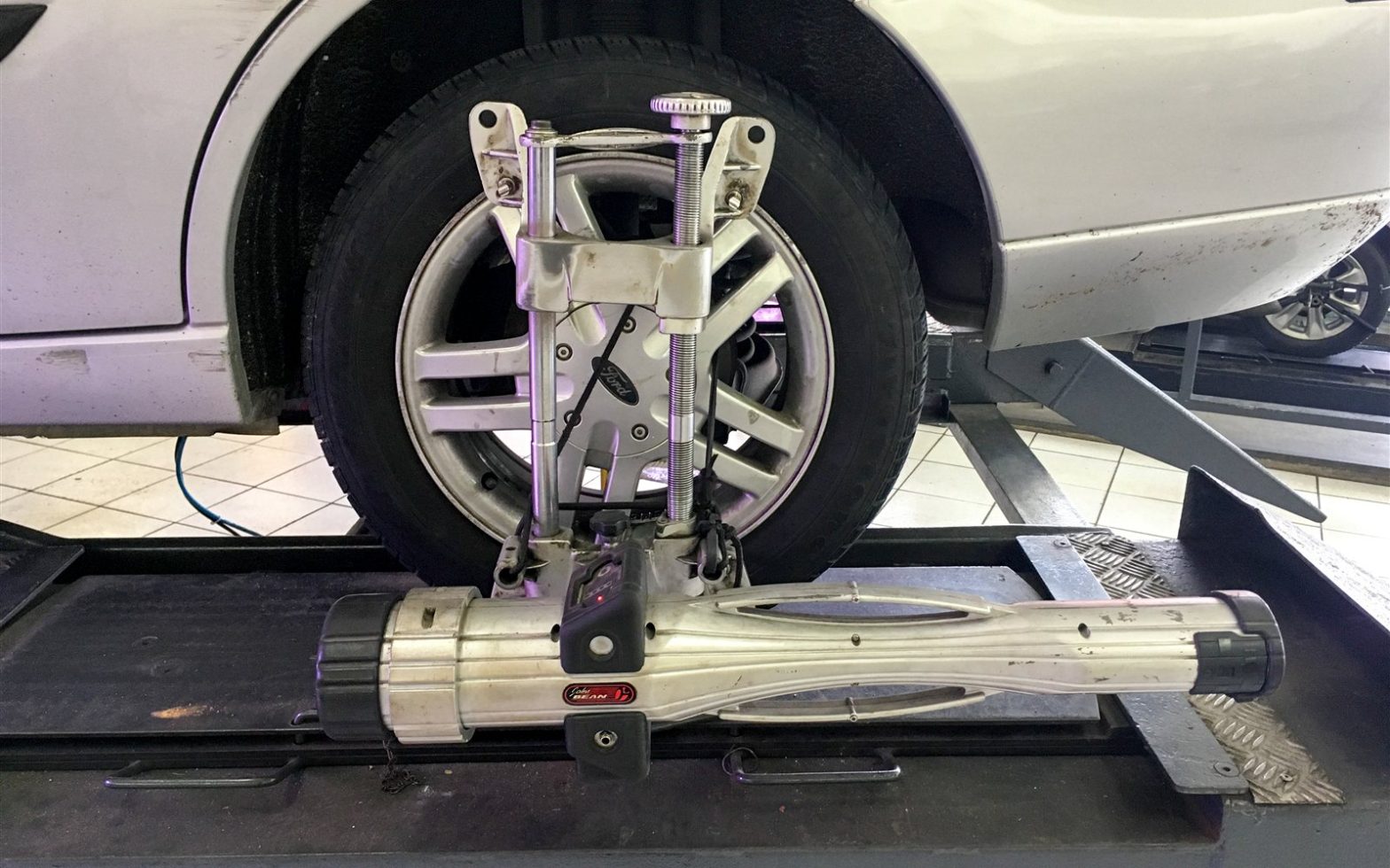 Equipamento de alinhamento 3D fixado na roda de um carro em oficina